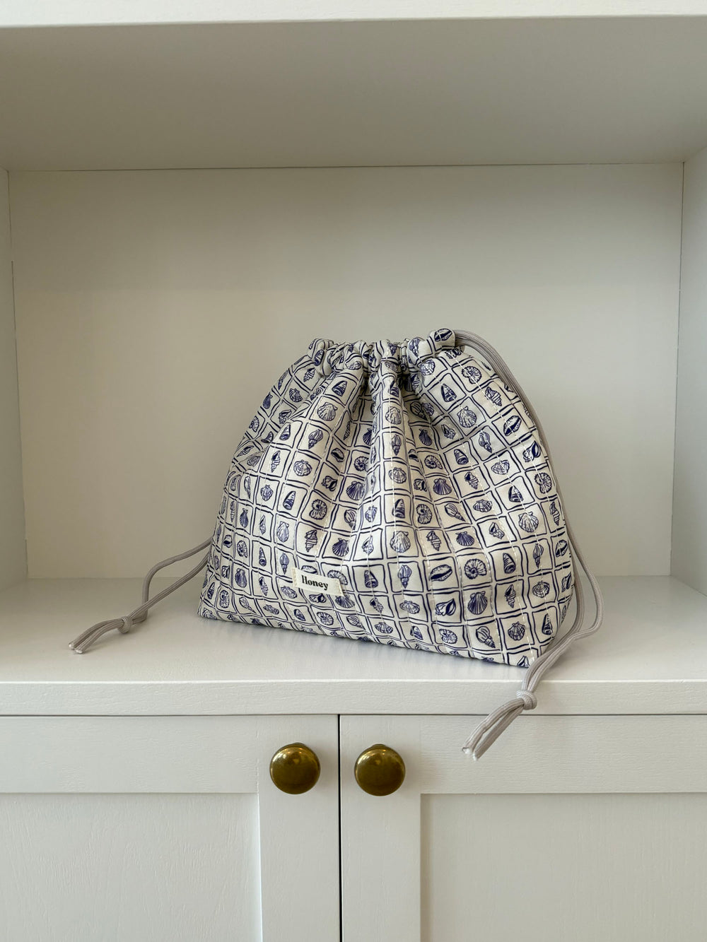 Honey stor toilettaske - Hvid med lilla konkylier